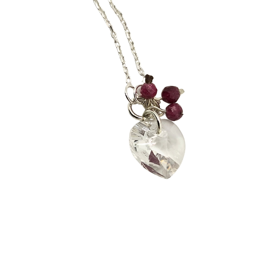 Crystal clear heart pendant with three ruby dangles hanging on a sterling silver necklace chain